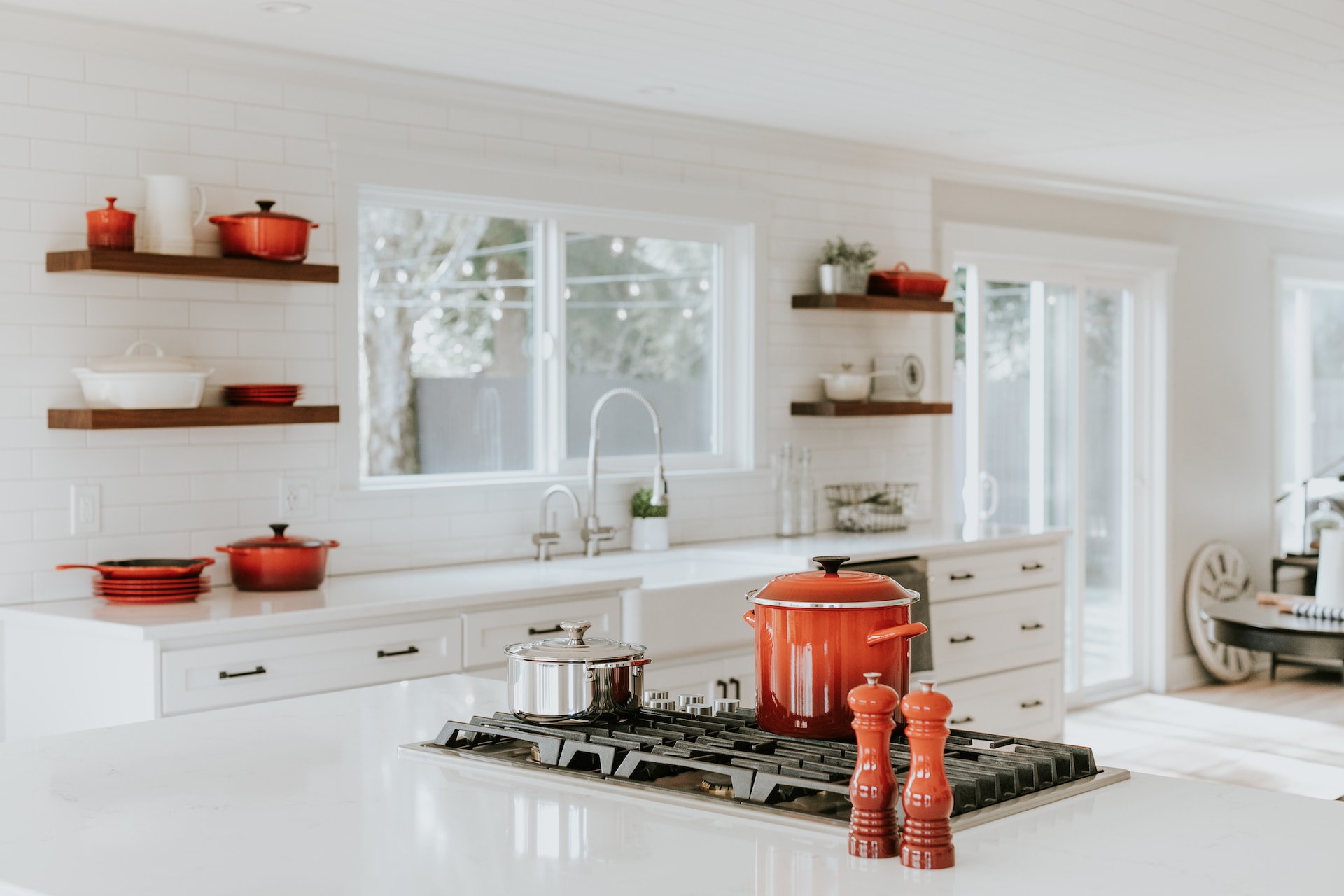 Red pots and pans in a white kitchen