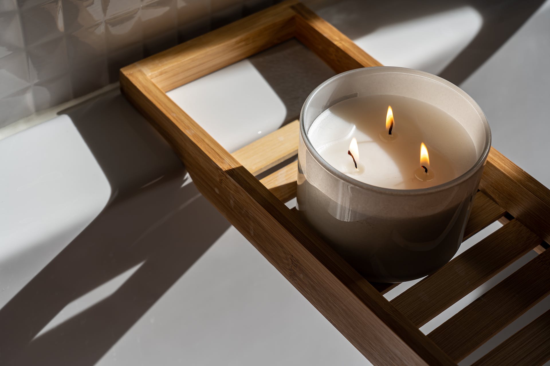 A candle on a wooden tray in the bathroom